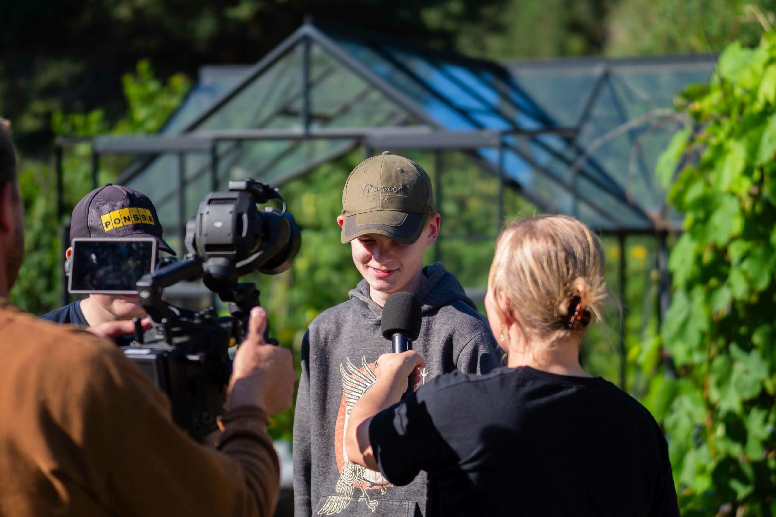 Nuorta haastatellaan, haastattelijalla on kädessään mikrofoni ja toinen henkilö kuvaa kameralla.