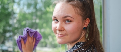 4H-siivousyrittäjä pesemässä ikkunaa.