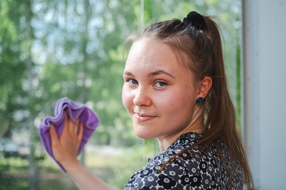 4H-siivousyrittäjä pesemässä ikkunaa.