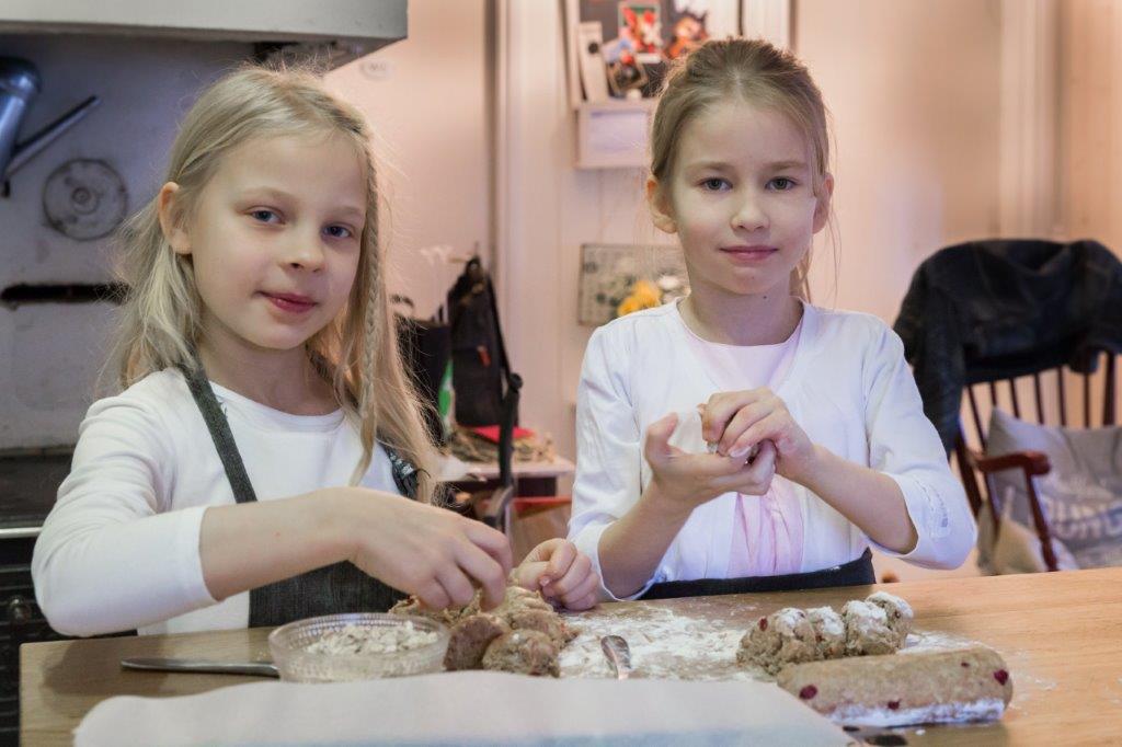 Kaksi lasta leipoo pikkuleipiä