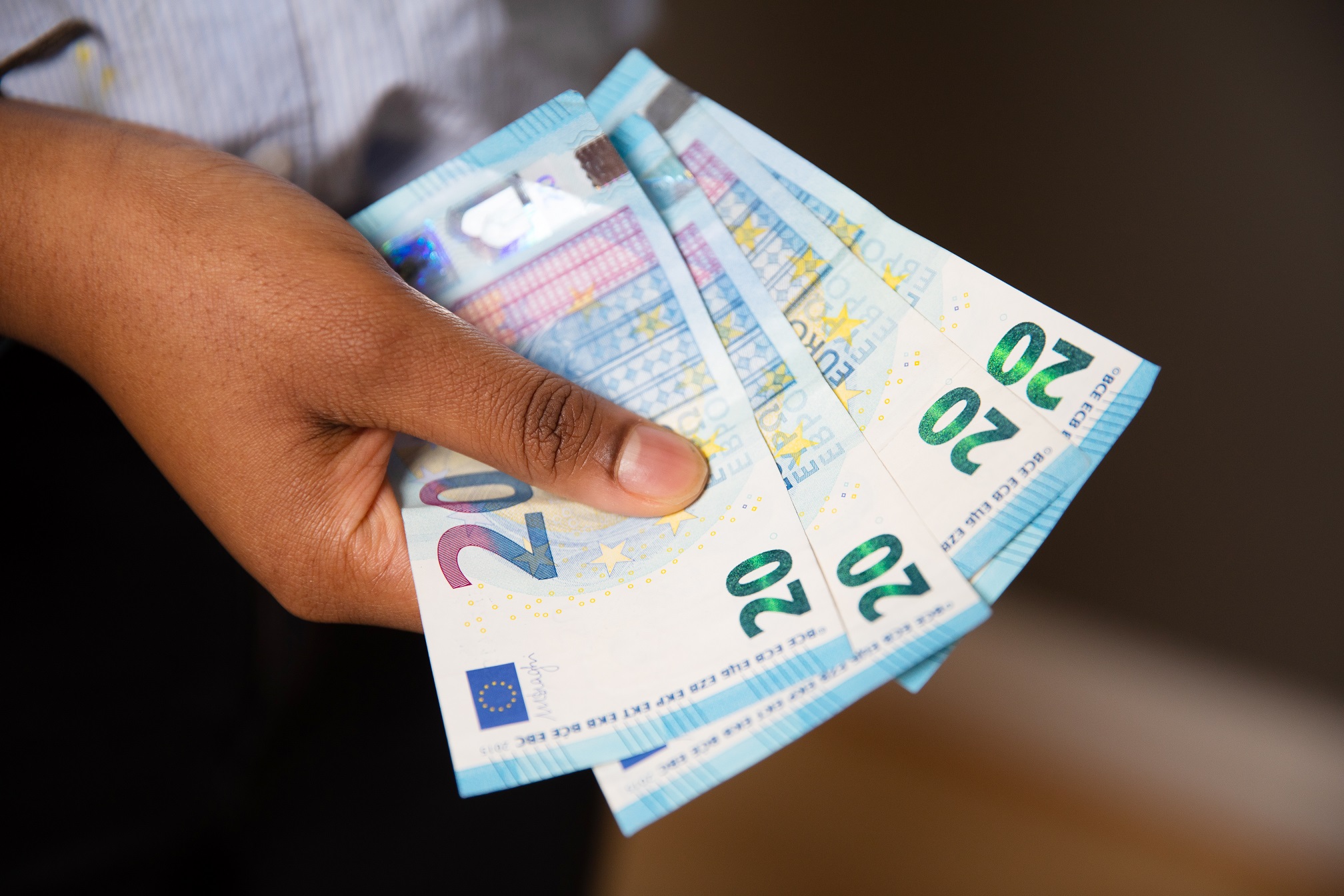 Kädessä neljä 20 euron seteliä