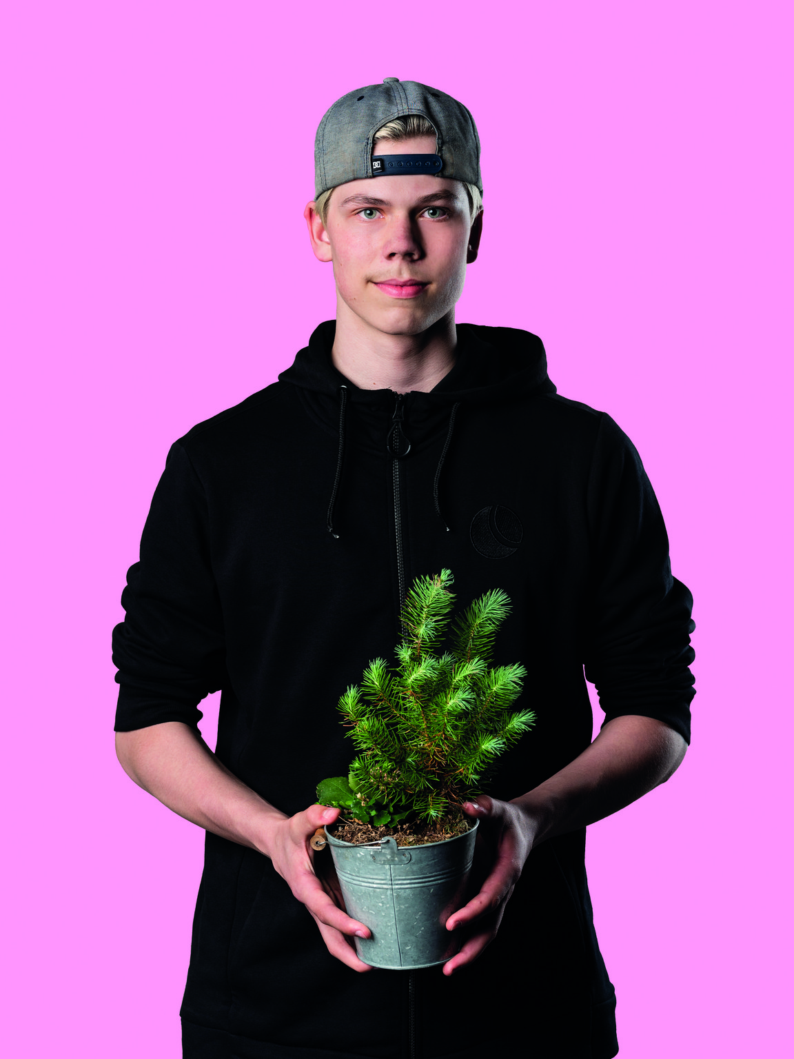 4H yrittäjä pitää käsissään kuusen taimea, joka on sinkkiämpärissä.