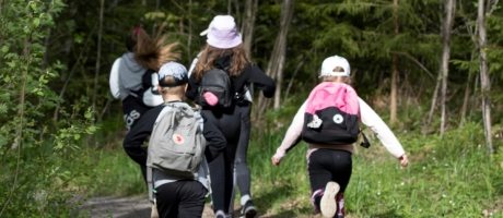Lapset juoksevat metsäpolulla.