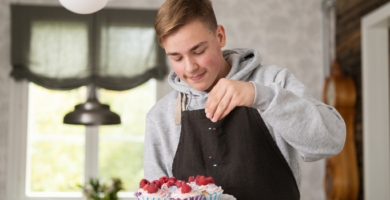 4H-yrittäjä koristelemassa tekemiään kuppikakkuja.
